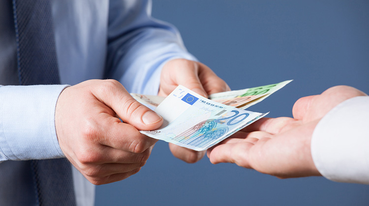 Geschäftsmann legt Banknoten in die Hand des Geldempfängers